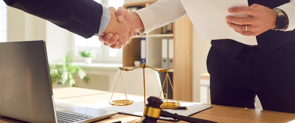 Anwalt und Mandant geben sich die Hände als Zeichen des gegenseitigen Vertrauens im Bußgeldverfahren