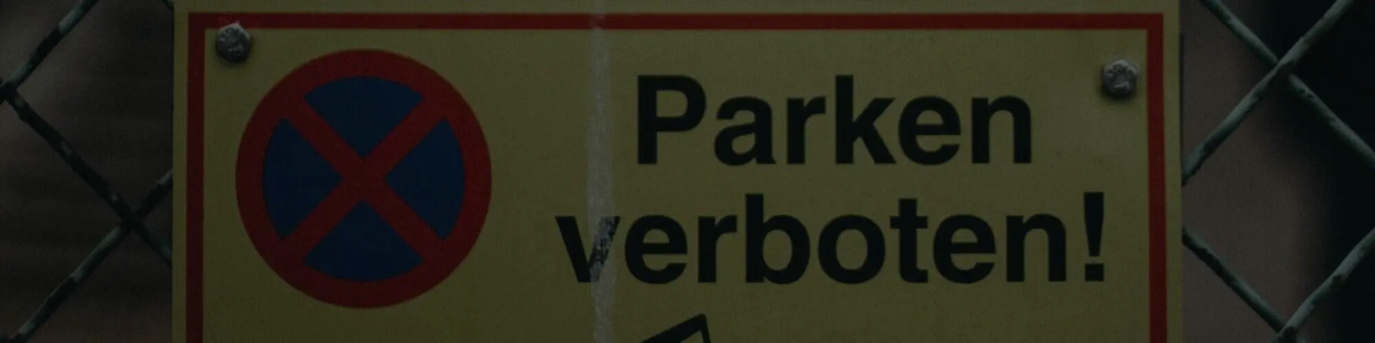 Parkverbotsschild an einem Zaun befestigt.
