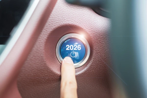 Frau drückt auf einen Start-Knopf im Auto loading=