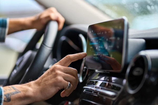 Auch Fahrzeug-Displays können unter das Handyverbot fallen Mann bedient Display im Auto