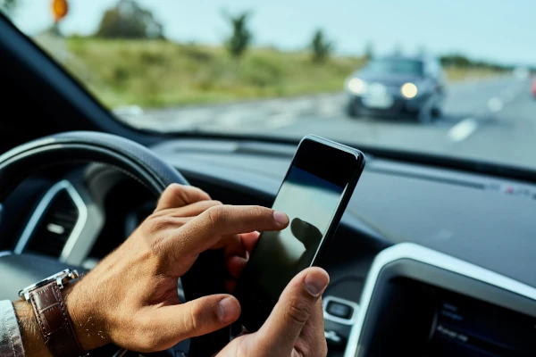Mann nutzt Handy am Steuer