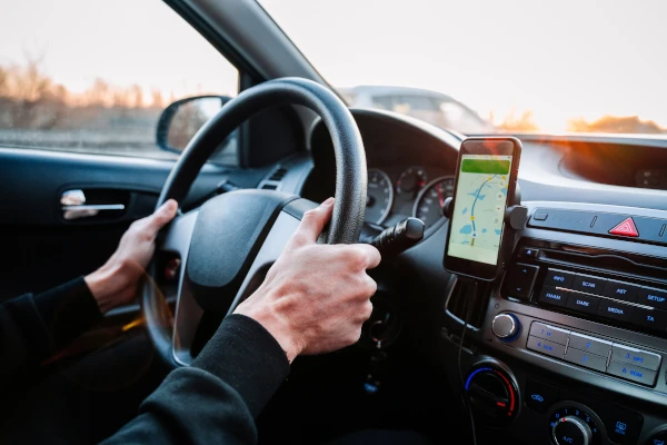 Handy am Steuer: Was ist erlaubt? Ein Handy steckt in einer Halterung und wird als Navigationsgerät genutzt.