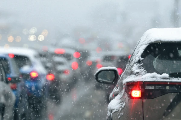 Autos stehen bei Schnee im Stau