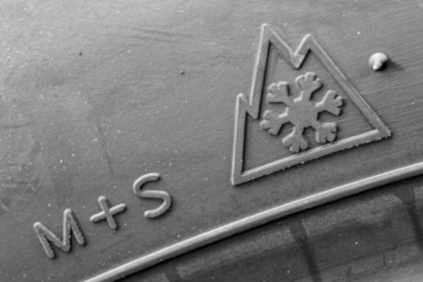 Nahaufnahme eines Winterreifens mit M+S- und Alpine-Symbol
