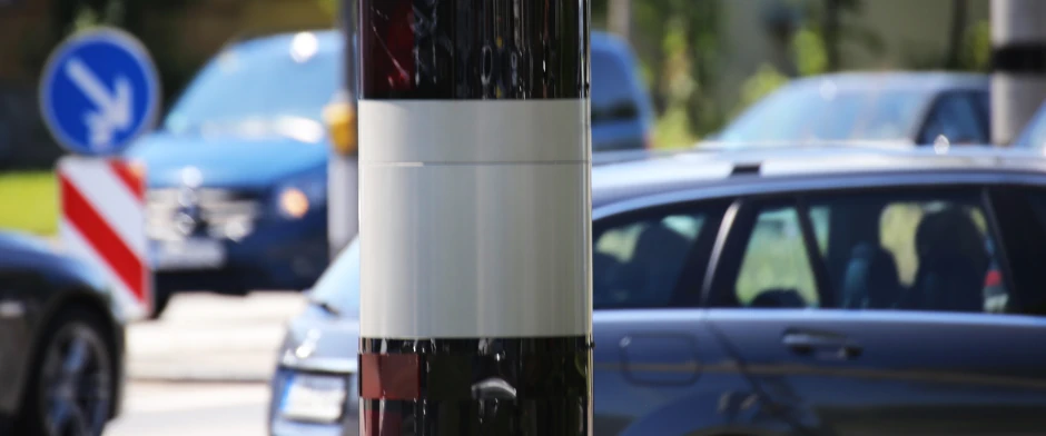 Nahaufnahme eines Blitzers und vorbeifahrende Autos