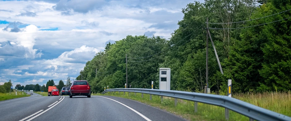 Ein Blitzer an einer Landstraße und vorbeifahrende Autos © M-Production/Shutterstock.com