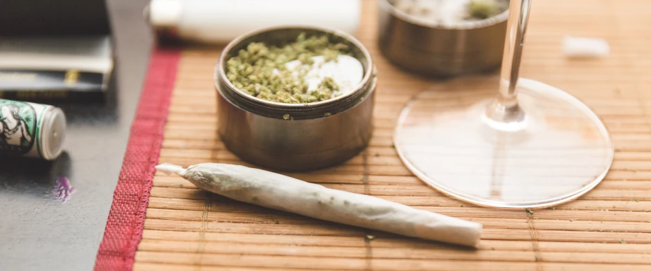 Cannabis und Alkohol: doppelte Gefahr für die Fahrtüchtigkeit Ein Joint und ein Weinglas als Symbol für gleichzeitigen Drogen- und Alkoholkonsum.