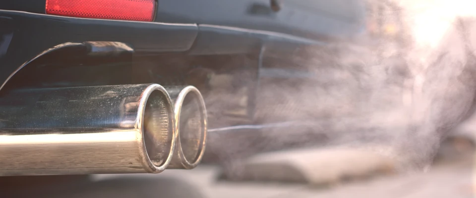 Diesel–Skandal: Manipulation der Abgaswerte von Dieselmotoren Nahaufnahmen von rauchigen Doppelauspuffrohren