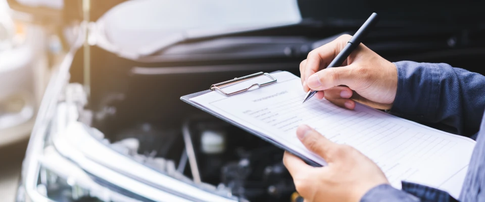 Gutachten im Verkehrsrecht Ein Kfz-Gutachter füllt ein Formular aus